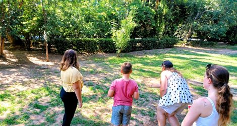 Family playing an ancient Greek target game in the National Garden of Athens.