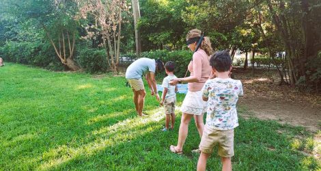 Blindfold game in Athens, parents guided by children at the National Garden.