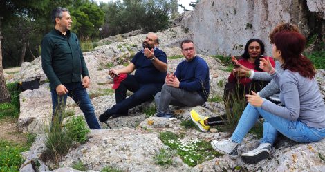 Group of friends discuss ancient democracy on Pnyx Hill.